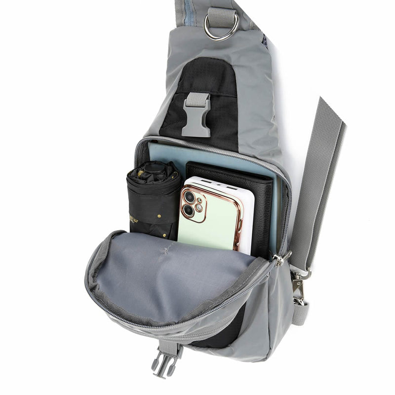 Load image into Gallery viewer, Front quick-access pocket of the Riderbag sling bag open with a phone, sunglasses and keys inside