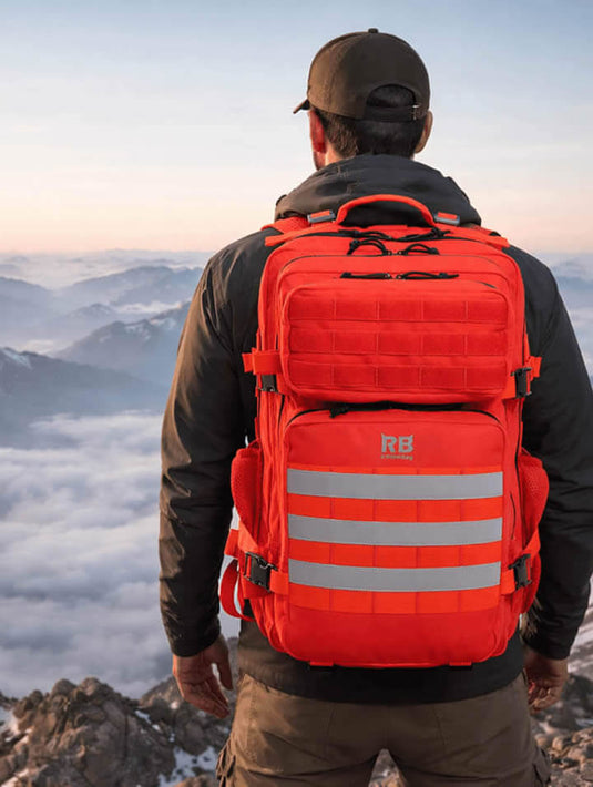 hiker wearing a red 45l riderbag backpack with reflective stripes on a mountain top